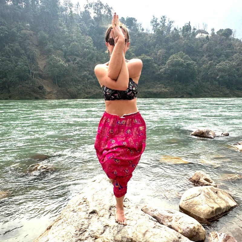 Angela Baroni outdoors with arms raised, testimonial client