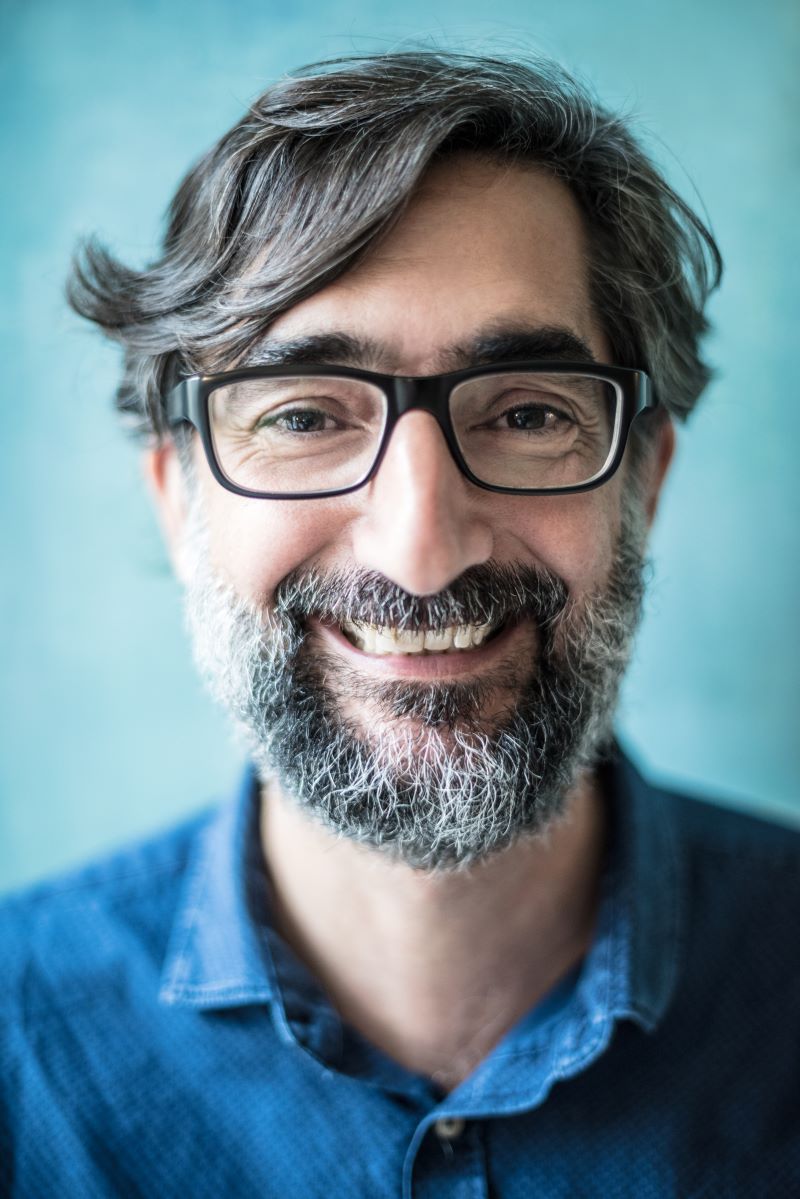 Smiling man with glasses and salt-and-pepper beard representing Packard Communications client testimonials