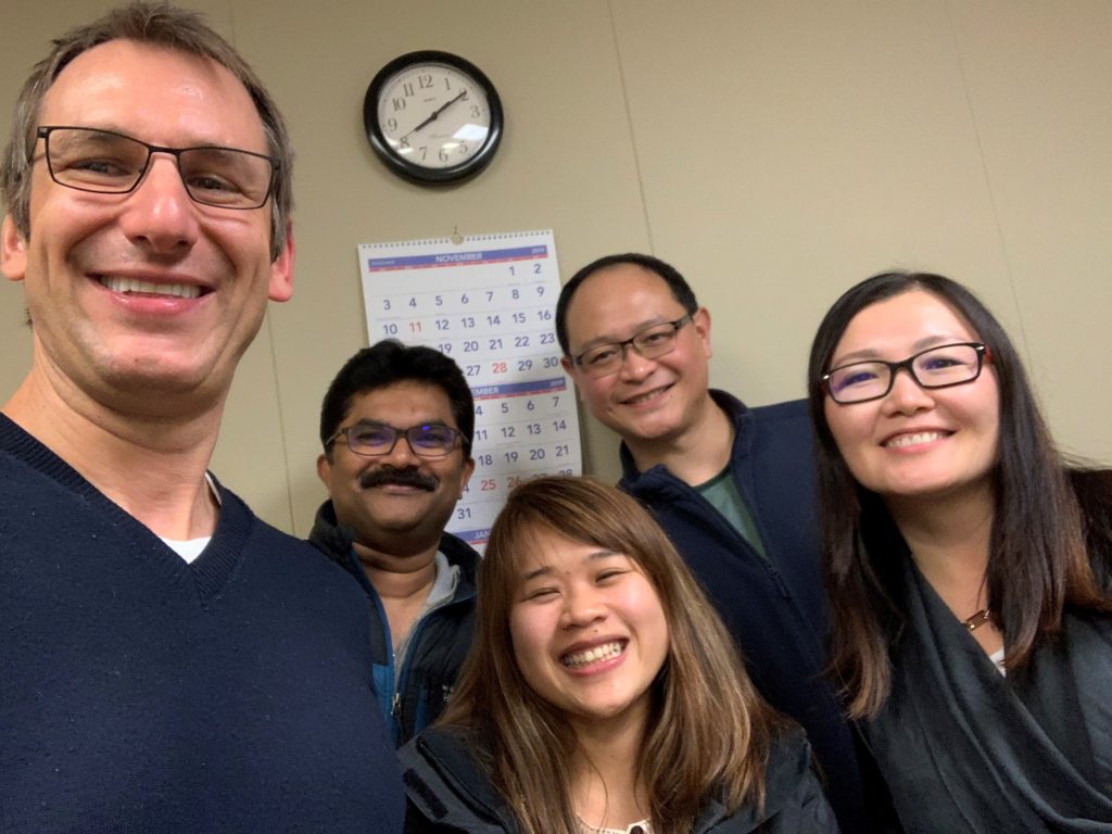 Accent modification students smiling with their instructor during an in-person pronunciation class.