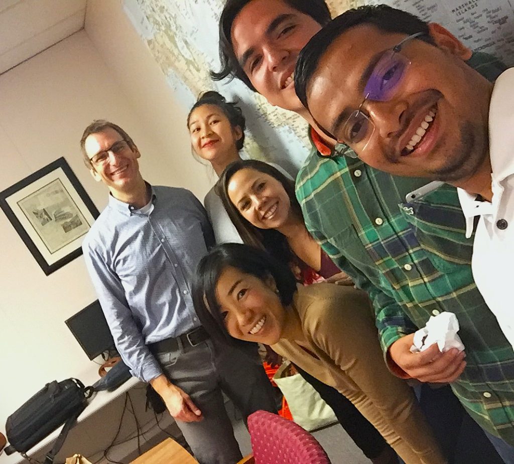 Diverse group of learners and instructor celebrating progress in American English pronunciation training.