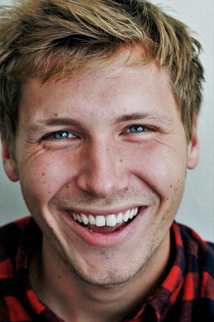 Young man with a bright smile, showcasing confidence and clarity in communication.